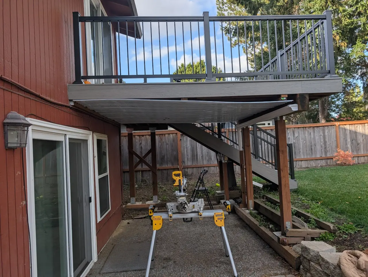 Second-story composite deck with aluminum railing and an under-deck ceiling being installed